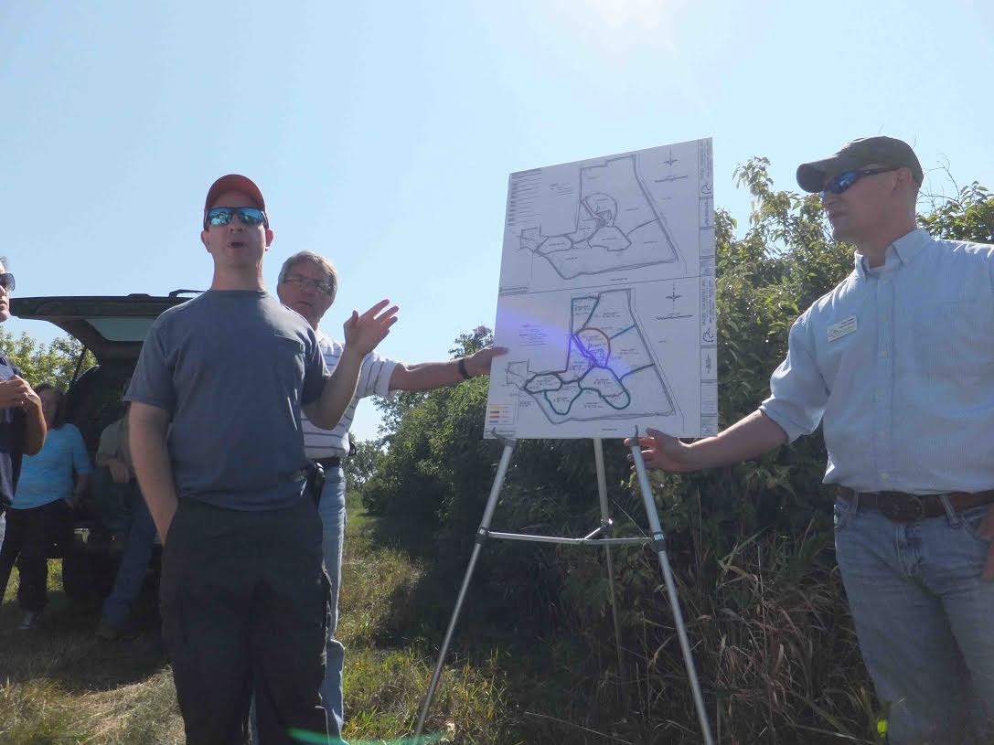 Chris May, directeur de la restauration de l’habitat à l’organisme The Nature Conservancy, à gauche, explique les phases de la construction et de la restauration planifiées du marais Érié, situé près de la frontière entre le Michigan et l’Ohio. Photo : Melissa Molenda/TNC.