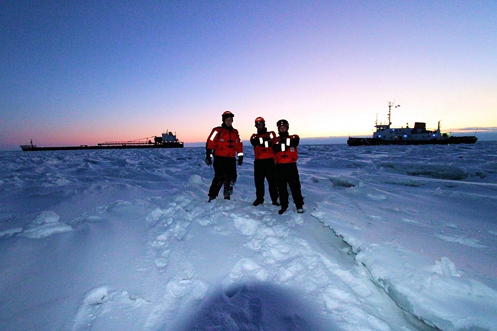 Chief Petty Officer Nick Gould, Petty Officer 1st Class Dwayne Matthews and Petty Officer 3rd Class Angelo Barnett stand on frozen Lake Huron with the motor vessel Capt. Henry Jackman and Coast Guard Cutter Bristol Bay in the background, Feb. 10, 2015. As part of Operation Coal Shovel, the crew of the Bristol Bay broke the Jackman free from the ice and assisted it northbound. Credit: U.S. Coast Guard photo by Chief Petty Officer Nick Gould