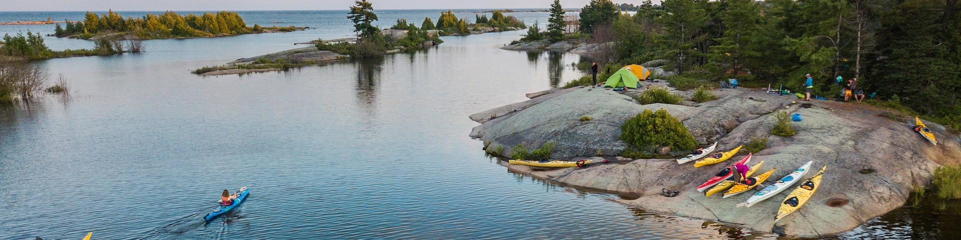 An aerial view of kayakers camping and paddling on the Great Lakes in northern Canada